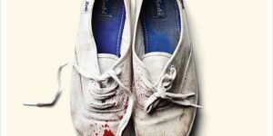White sneakers with red paint splatters, concert ticket details visible.