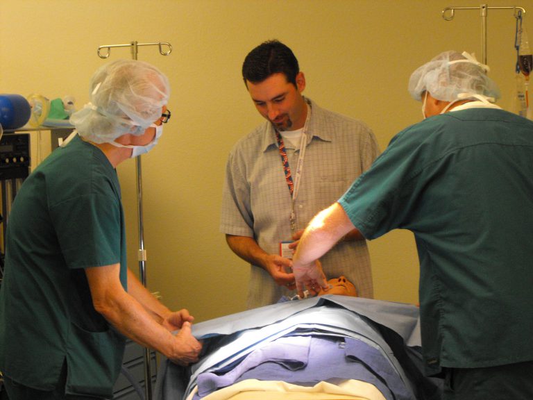 Surgical technicians practicing skills during training session in medical simulation lab.