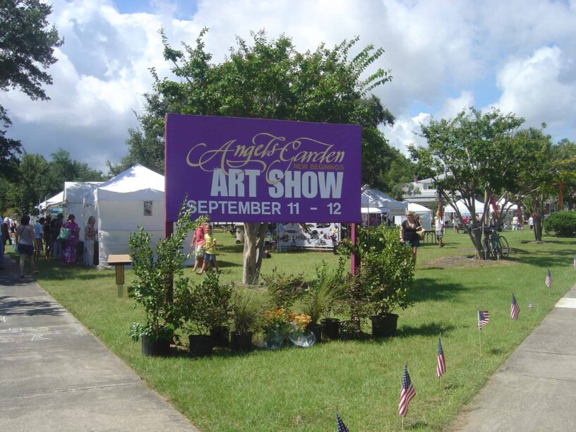 Outdoor art show at Angel's Garden with vibrant displays and visitors enjoying the event.