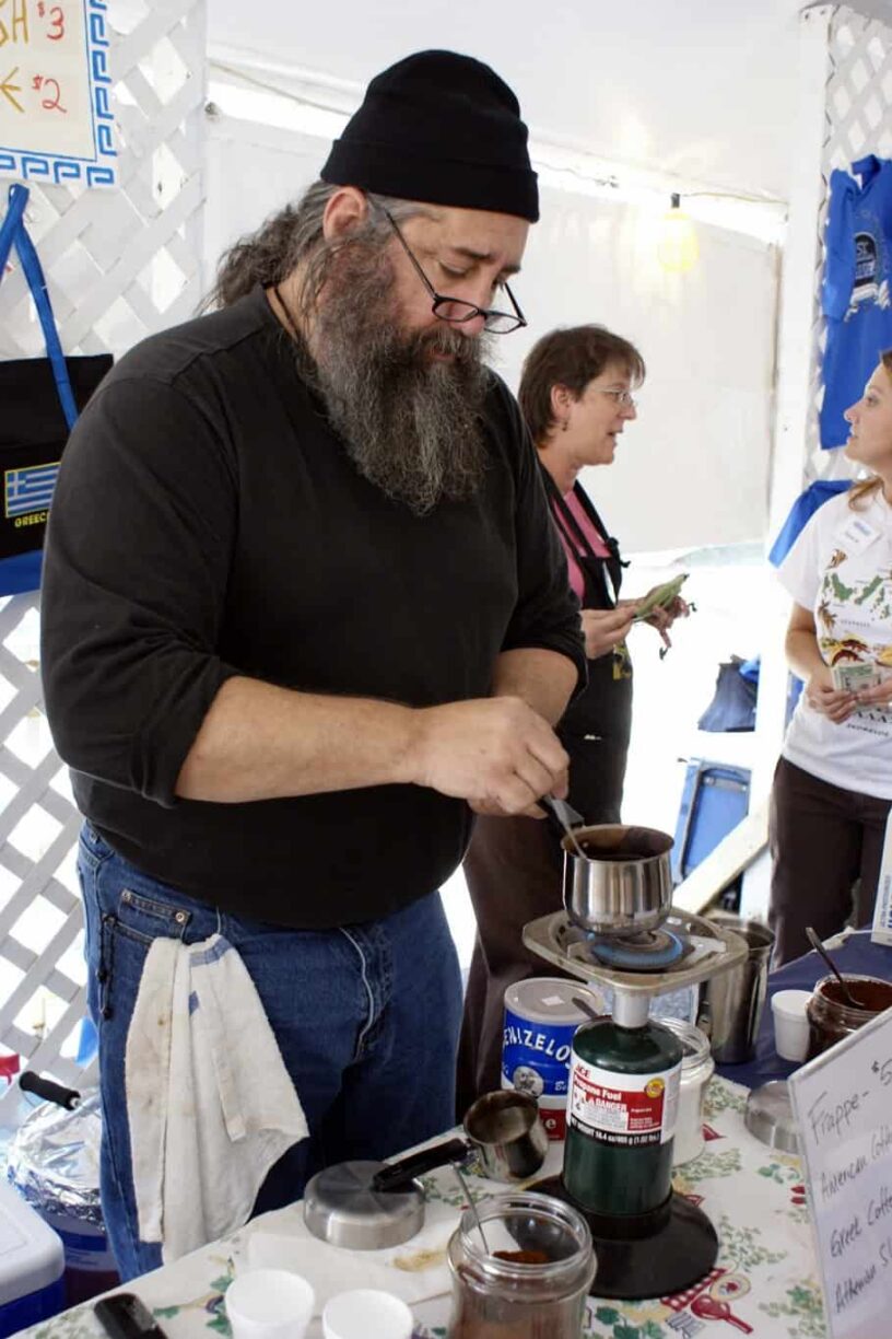 Man preparing traditional Greek coffee at Pensacola Greek Festival.