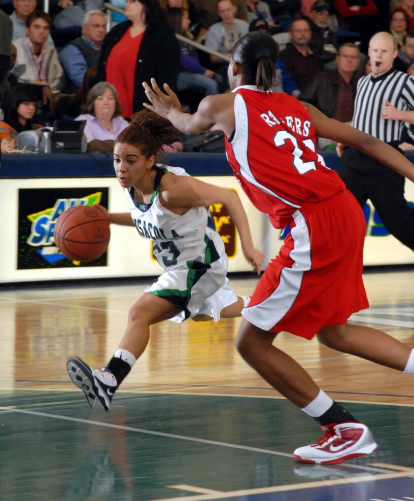 Basketball player dribbling past defender during a game at eCorsair event.