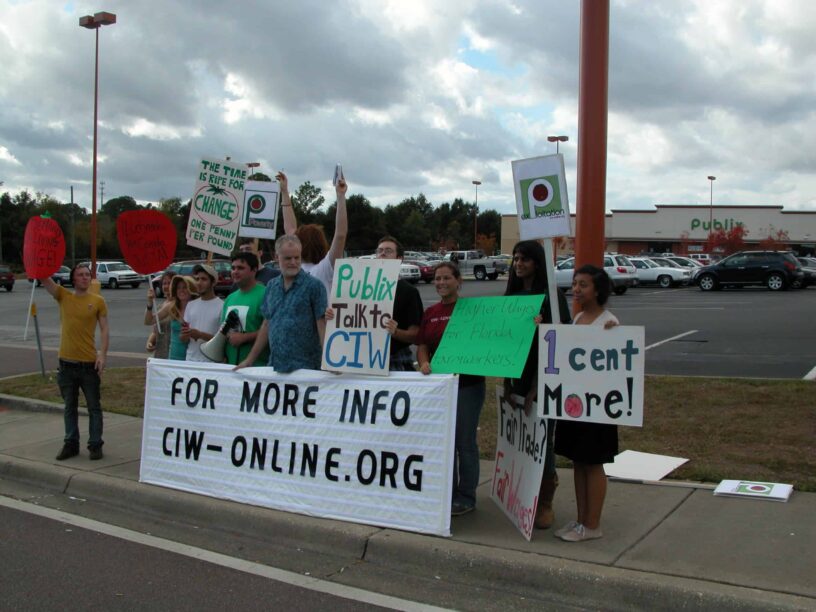 Group of protesters holding signs outside Publix advocating for farmworker rights.