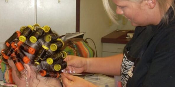 Cosmetology student applying hair rollers during a styling class at PJC.