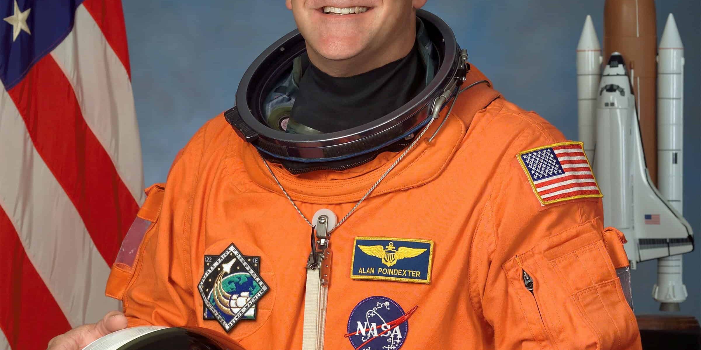 NASA astronaut Alan Poindexter in space suit with NASA and space shuttle patches.