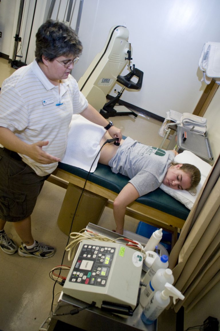 Medical technician performing diagnostic test on patient in clinical setting.