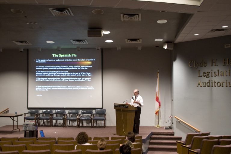 Expert presenting on Swine Flu pandemic at a seminar in an auditorium.