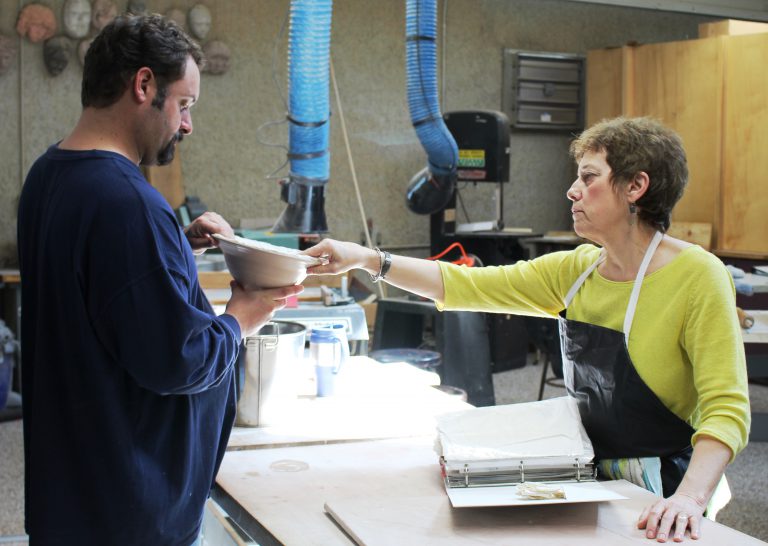 Artist Jo Stealey presents artwork to visitor at PSC Switzer Center.