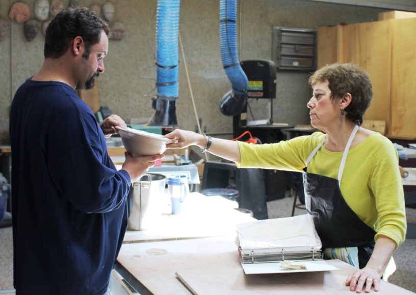 Artist Jo Stealey presents artwork to visitor at PSC Switzer Center.