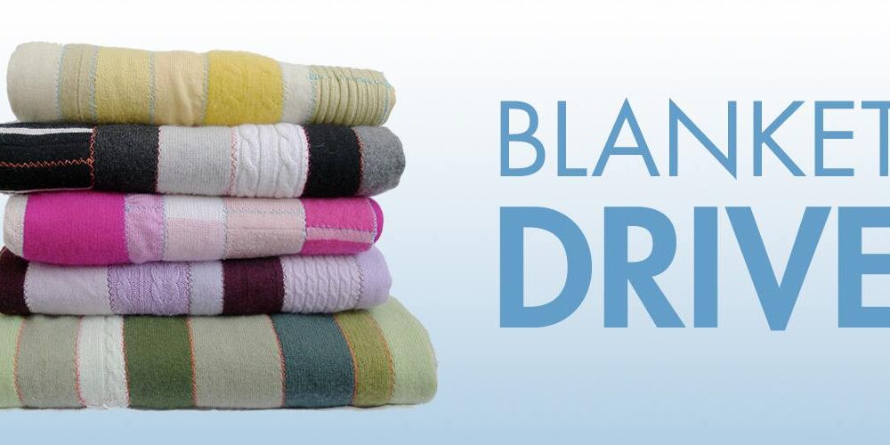 Stacked colorful blankets for a community blanket drive event.