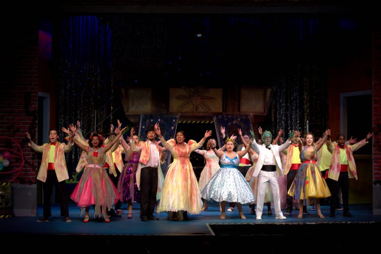 Colorful dance performance featuring diverse costumes and lively expressions.