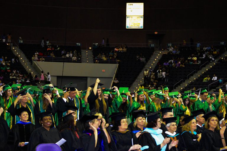 Graduates in caps and gowns at eCorsair graduation event.