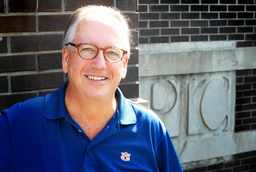 Jazz Band Member Celebrating Over 50 Years of Music Jazz band member smiling outdoors at PSC, showcasing enduring musical tradition.
