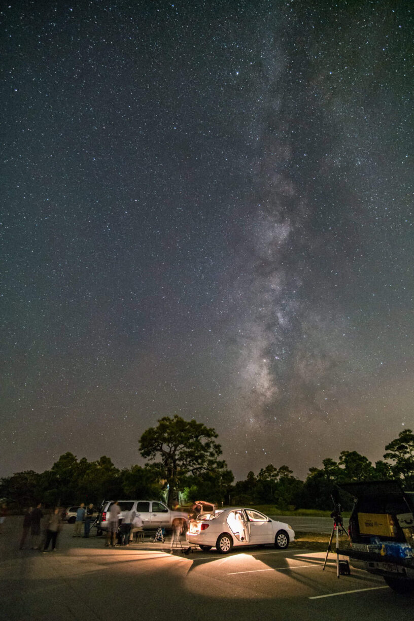 Stargazing Celebration at Night Night sky with the Milky Way and stars over a parking lot during amateur astronomers' event.