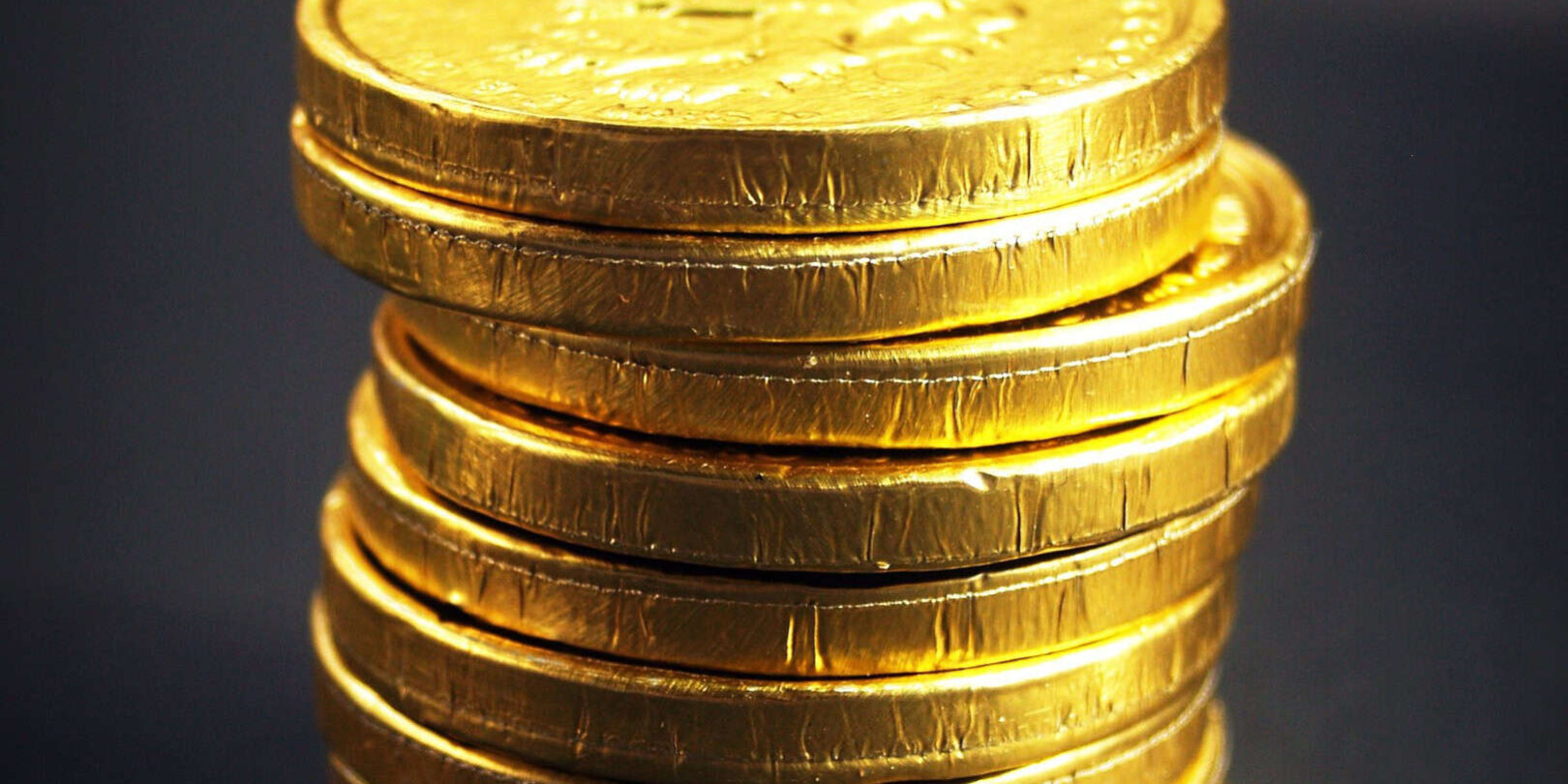 Gold coins stacked to represent wealth, taxes, and financial contributions.