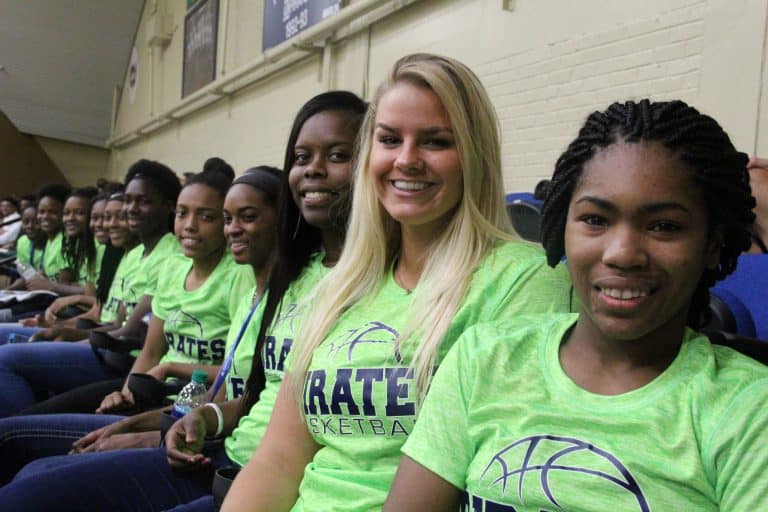 Diverse PSC sports team members wearing green jerseys at a team event.