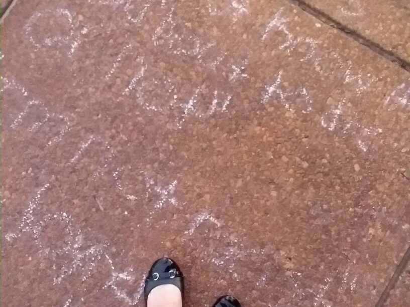 Student's chalk writing on sidewalk about new beginnings and second chances.