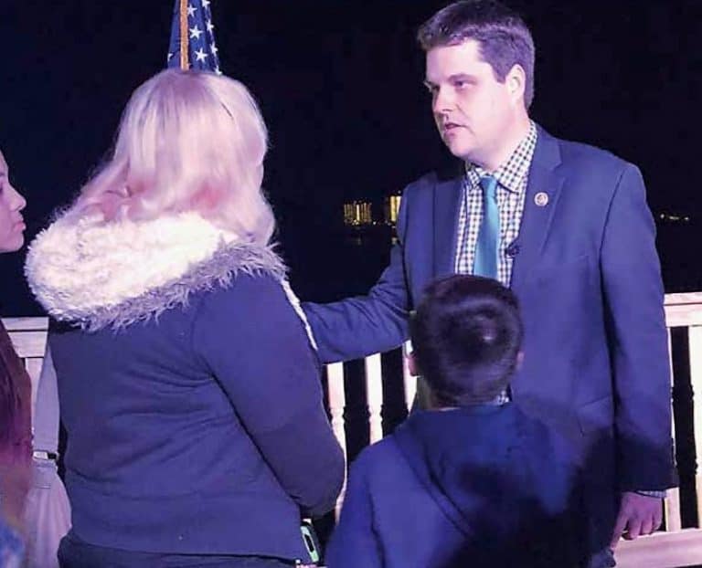 Man and woman in conversation during night event, outdoors.