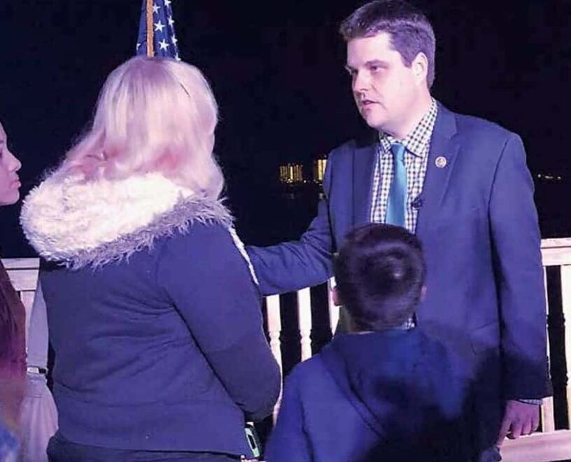 Man and woman in conversation during night event, outdoors.