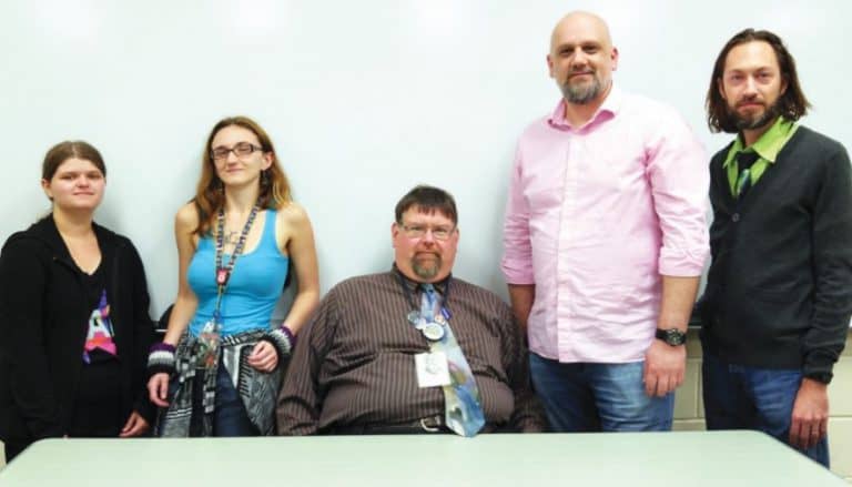 Group of students and faculty discussing philosophy at college event.