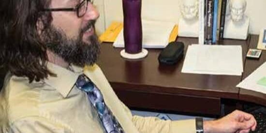 Student studying at desk with books and supplies on campus.