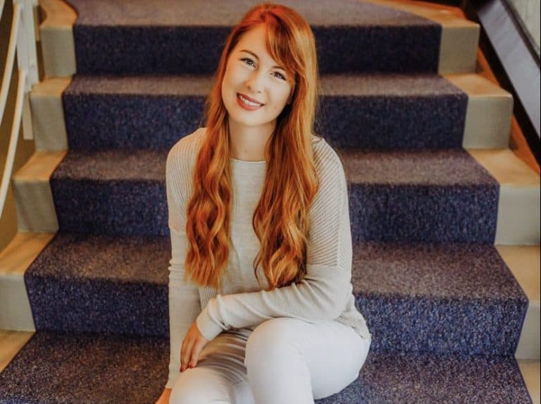 Student sitting on stairs at eCorsair, Pensacola State College campus.