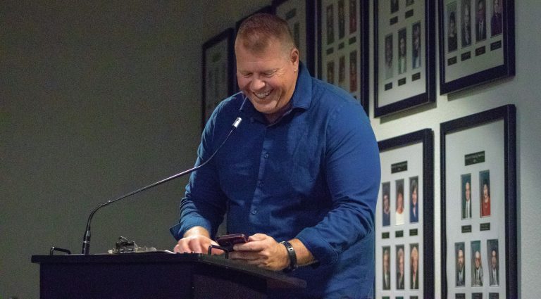 Student smiling at podium during eCorsair event at Pensacola State College.