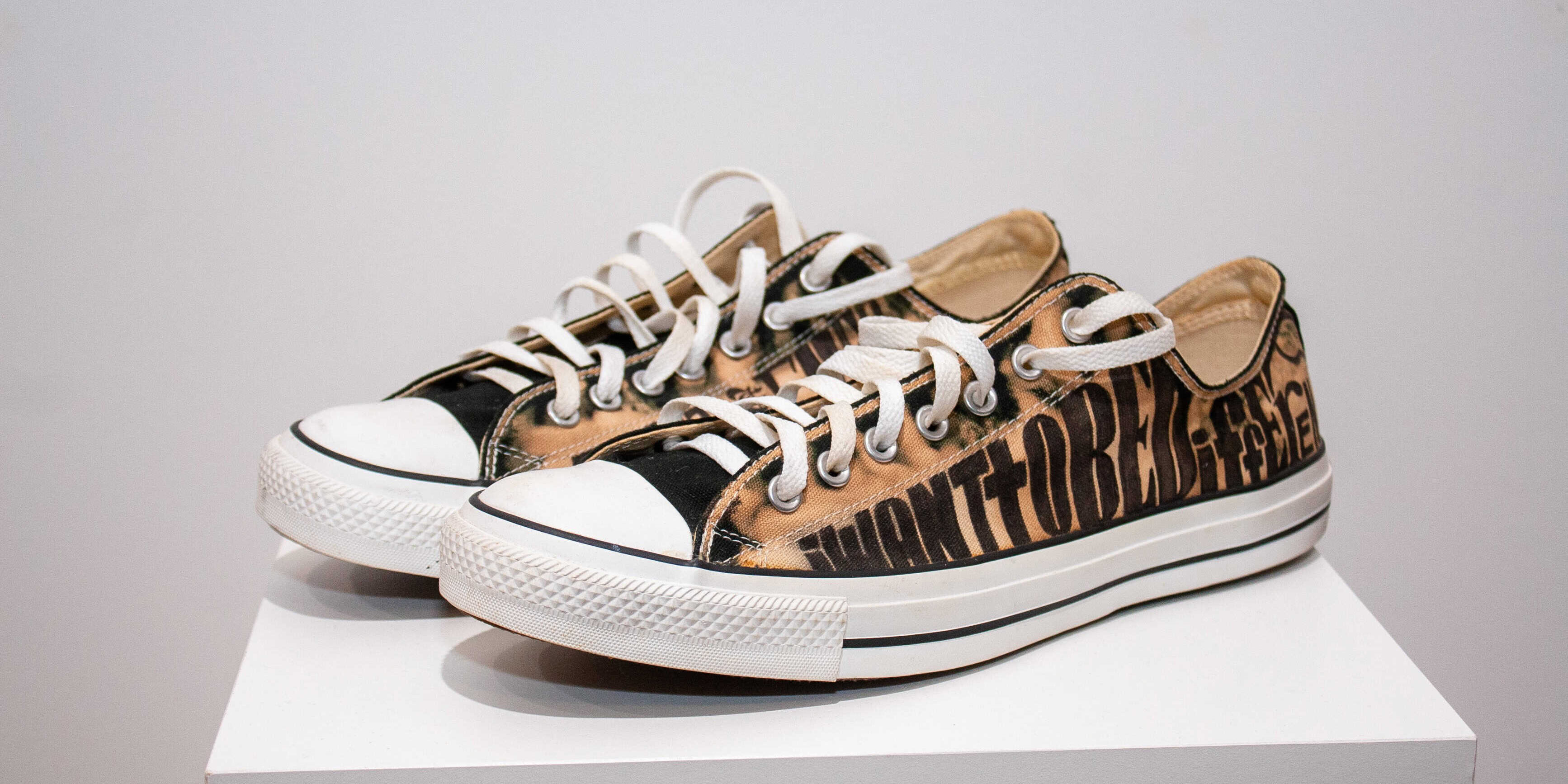 Vintage Converse sneakers with custom text design.