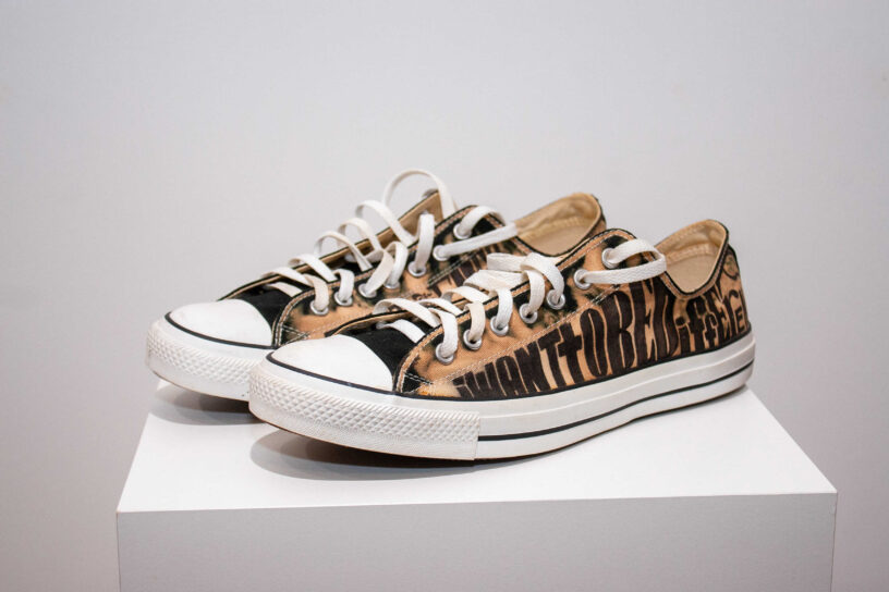 Vintage Converse sneakers with custom text design.