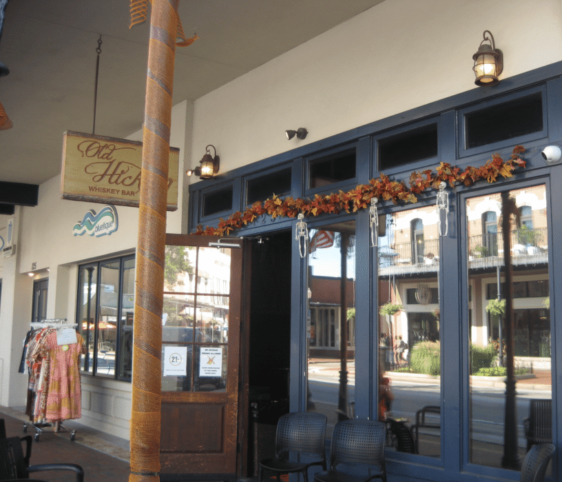 Cozy whiskey bar decorated for fall with autumn leaves and warm lighting.