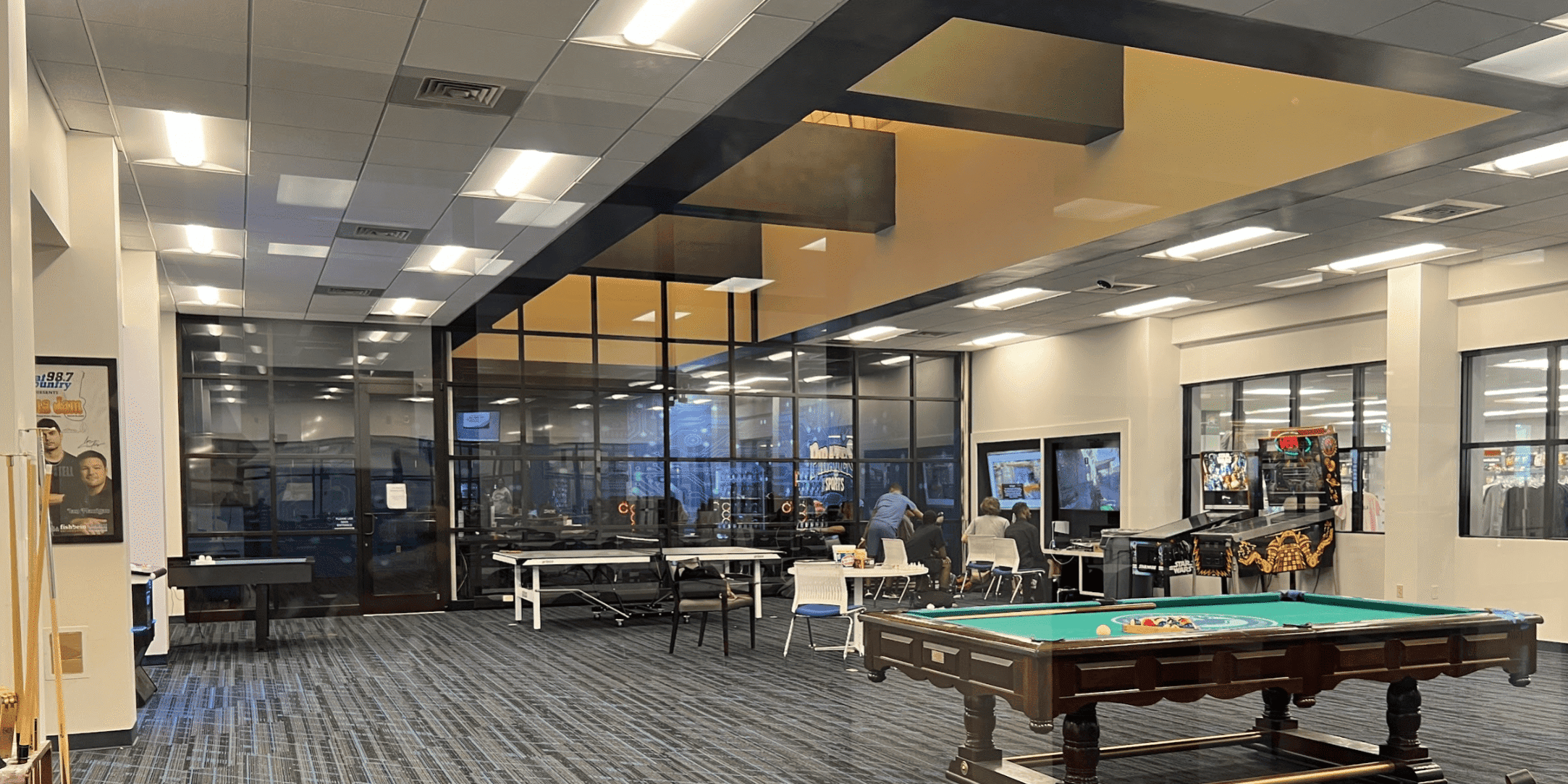 Relaxing student lounge with gaming tables and comfortable seating at eCorsair.