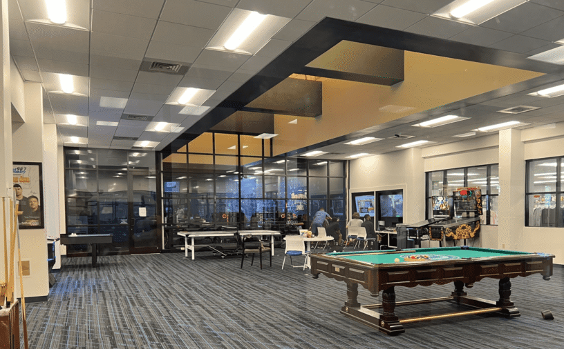 Relaxing student lounge with gaming tables and comfortable seating at eCorsair.