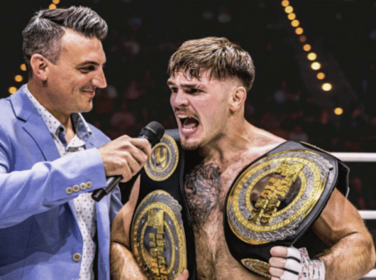 Boxer with championship belts being interviewed after victory.