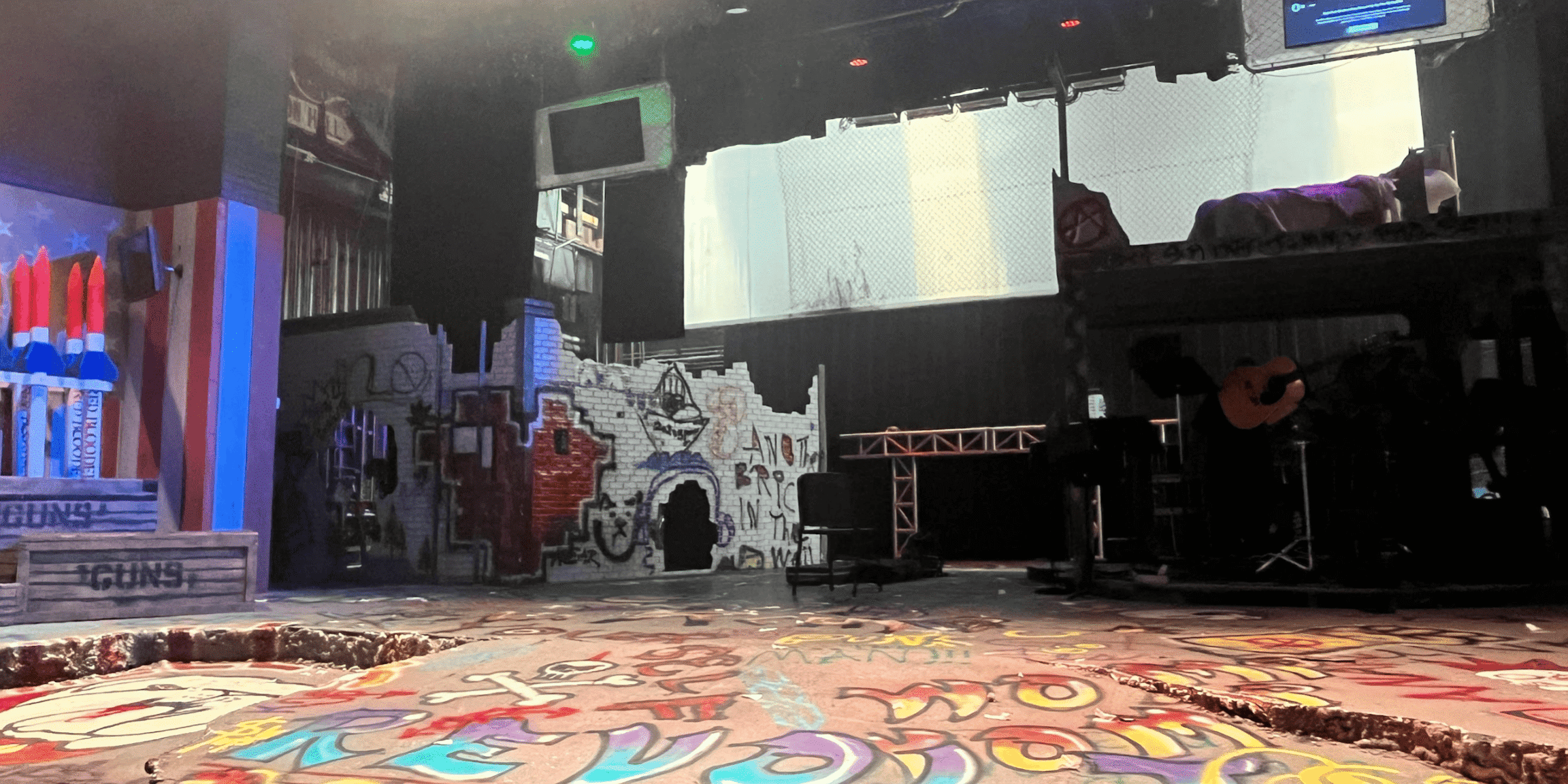 Stage setup with graffiti art and musical instruments for "The Son of Rage and Love" performance.