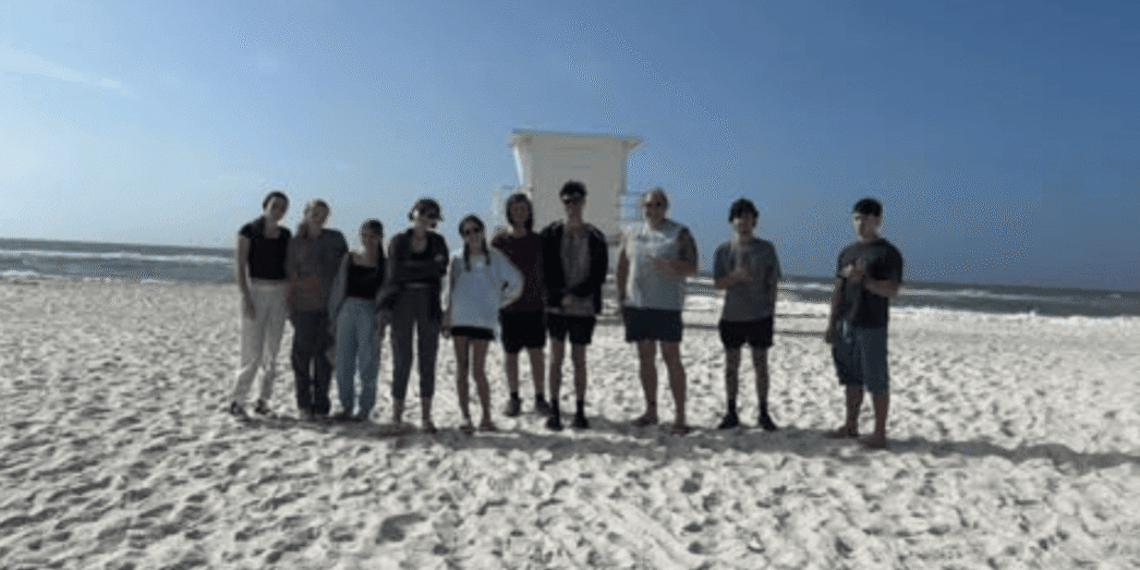Group of volunteers cleaning Pensacola Beach during Beach Clean-up Extravaganza.