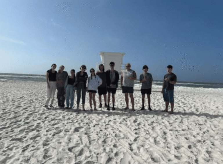 Group of volunteers cleaning Pensacola Beach during Beach Clean-up Extravaganza.