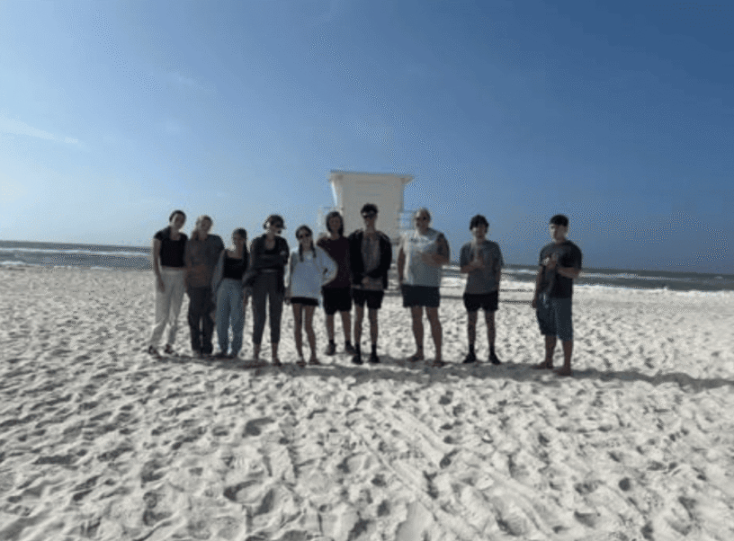 Group of volunteers cleaning Pensacola Beach during Beach Clean-up Extravaganza.