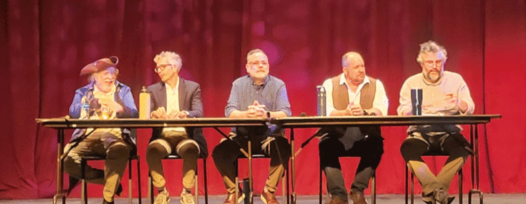 Panel of five people speaking at PSC’s Constitution Day event on a stage with red curtains.