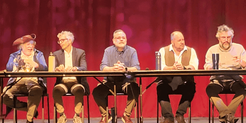 Panel of five people speaking at PSC’s Constitution Day event on a stage with red curtains.