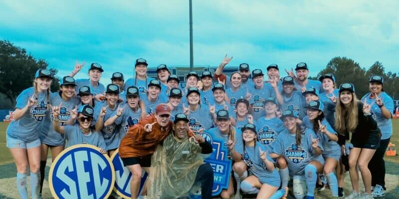 Youth soccer team celebrating victory at Pensacola sports field.