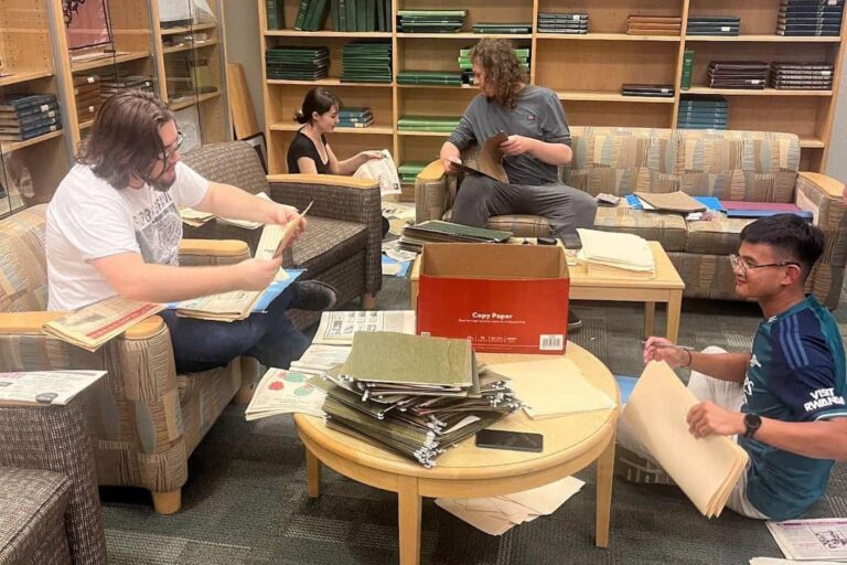 Archivists digitizing historical editions of The Corsair at Chadbourne Library.