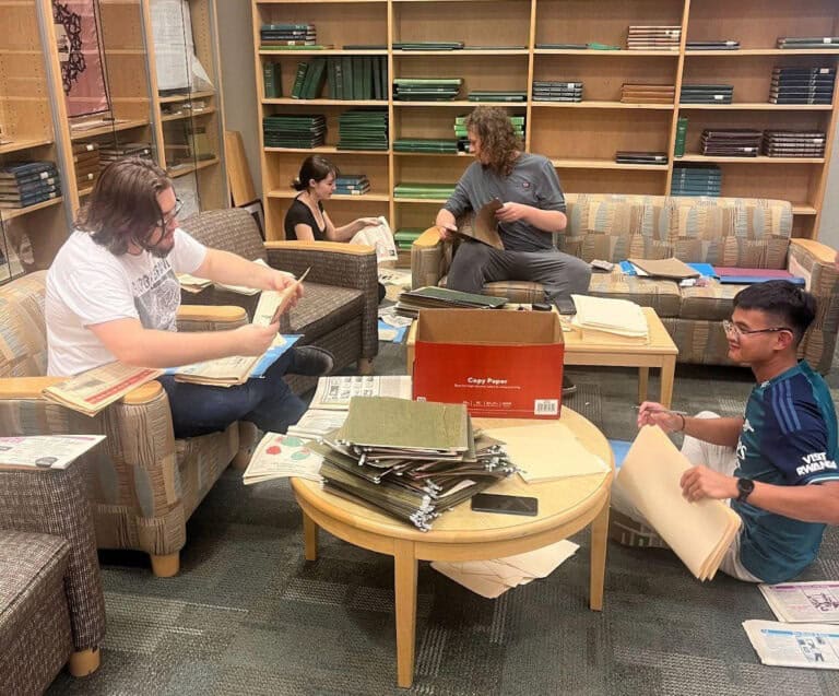 Archivists digitizing historical editions of The Corsair at Chadbourne Library.