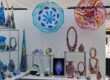 Vibrant glass sculptures and jewelry displayed at the arts festival.