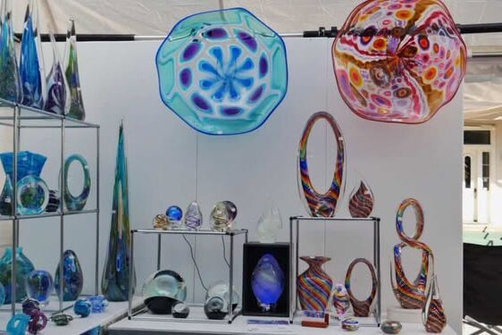 Vibrant glass sculptures and jewelry displayed at the arts festival.