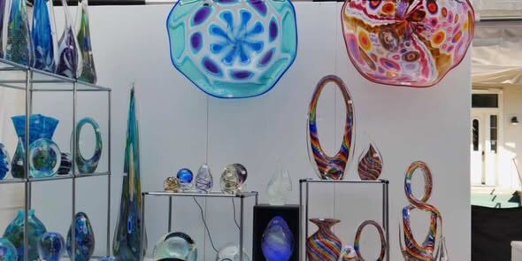 Vibrant glass sculptures and jewelry displayed at the arts festival.
